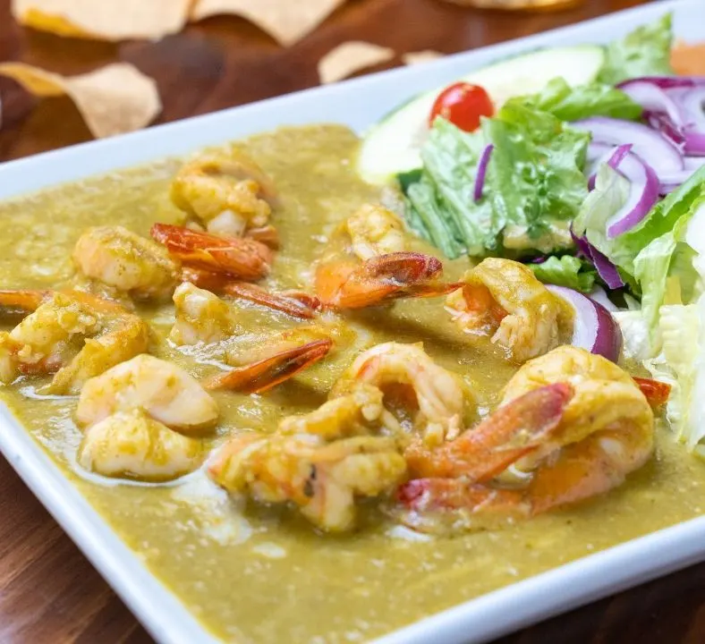 Camarones en salsa verde cremosa con ensalada.