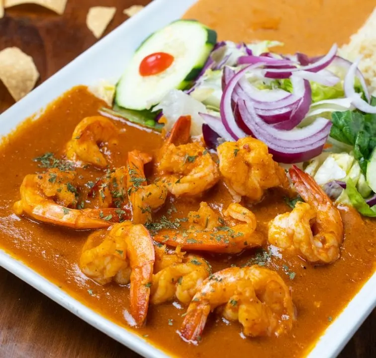 Camarones en salsa roja con ensalada y arroz.